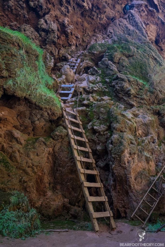 Ladders going down steep rock cliffs to Mooney Falls in Havasupai