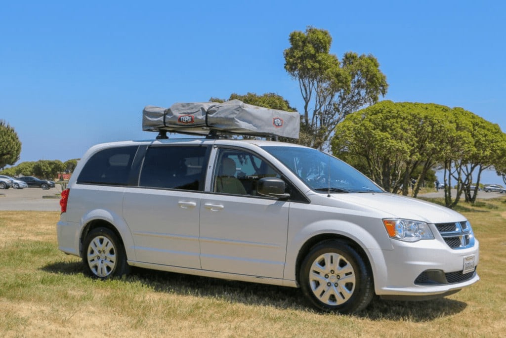White minivan converted into a campervan with a rooftop tent available for rent through Lost Campers