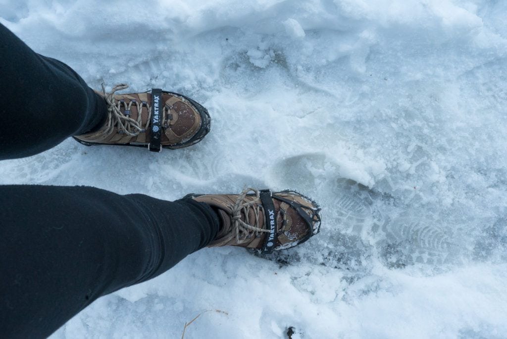 冬季徒步穿越冰雪的女子脚上穿着微钉的照片