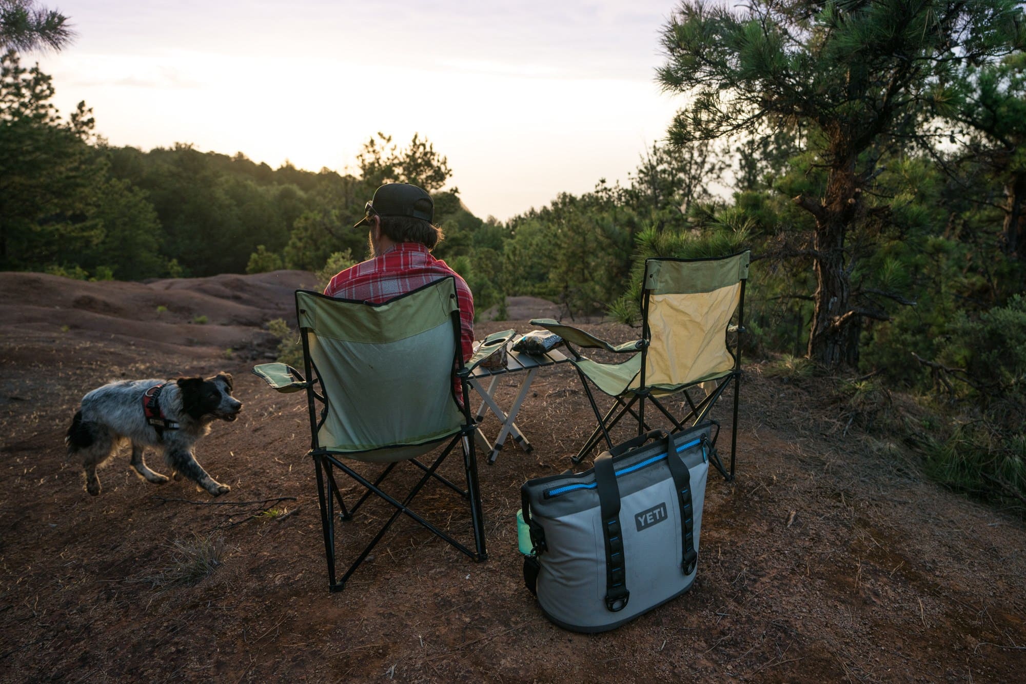GCI户外紧凑型露营桌旁边设置了两把露营椅。他们正在看日落。