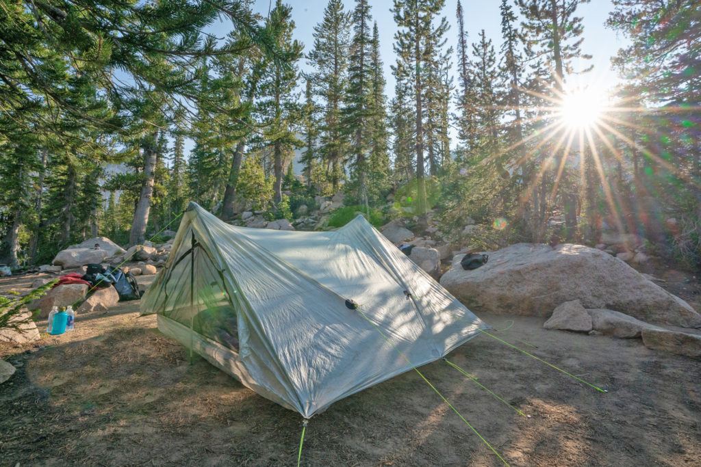 超轻Zpacks帐篷设置在偏远的露营地在森林里，阳光透过树木