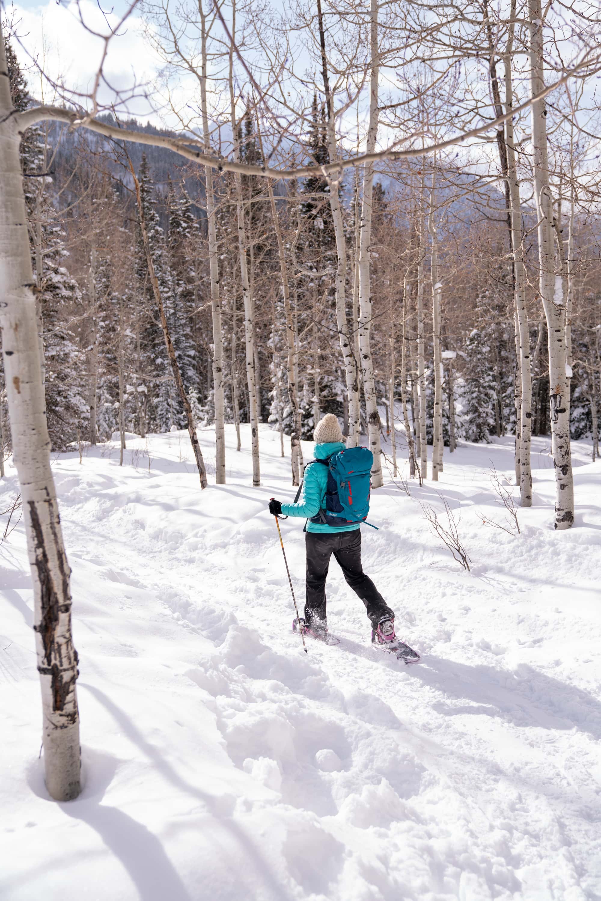 一个女人在冬天穿雪鞋走在平坦的小路上的特写