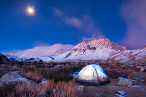 黄昏时分，帐篷搭在偏远的营地，背景是雪山