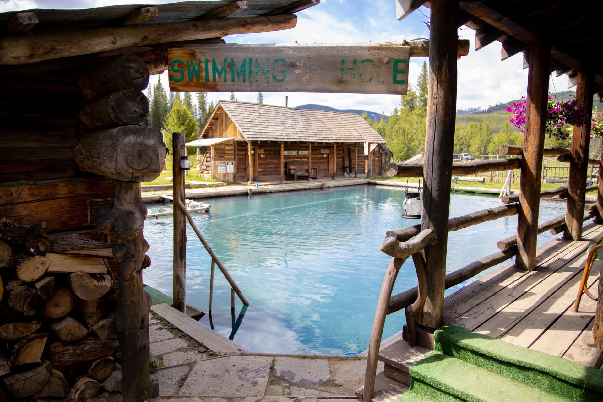 爱达荷州伯格道夫温泉度假村的一个大型温泉池。小木屋环绕着泳池，泳池入口悬挂着“游泳洞”的标志