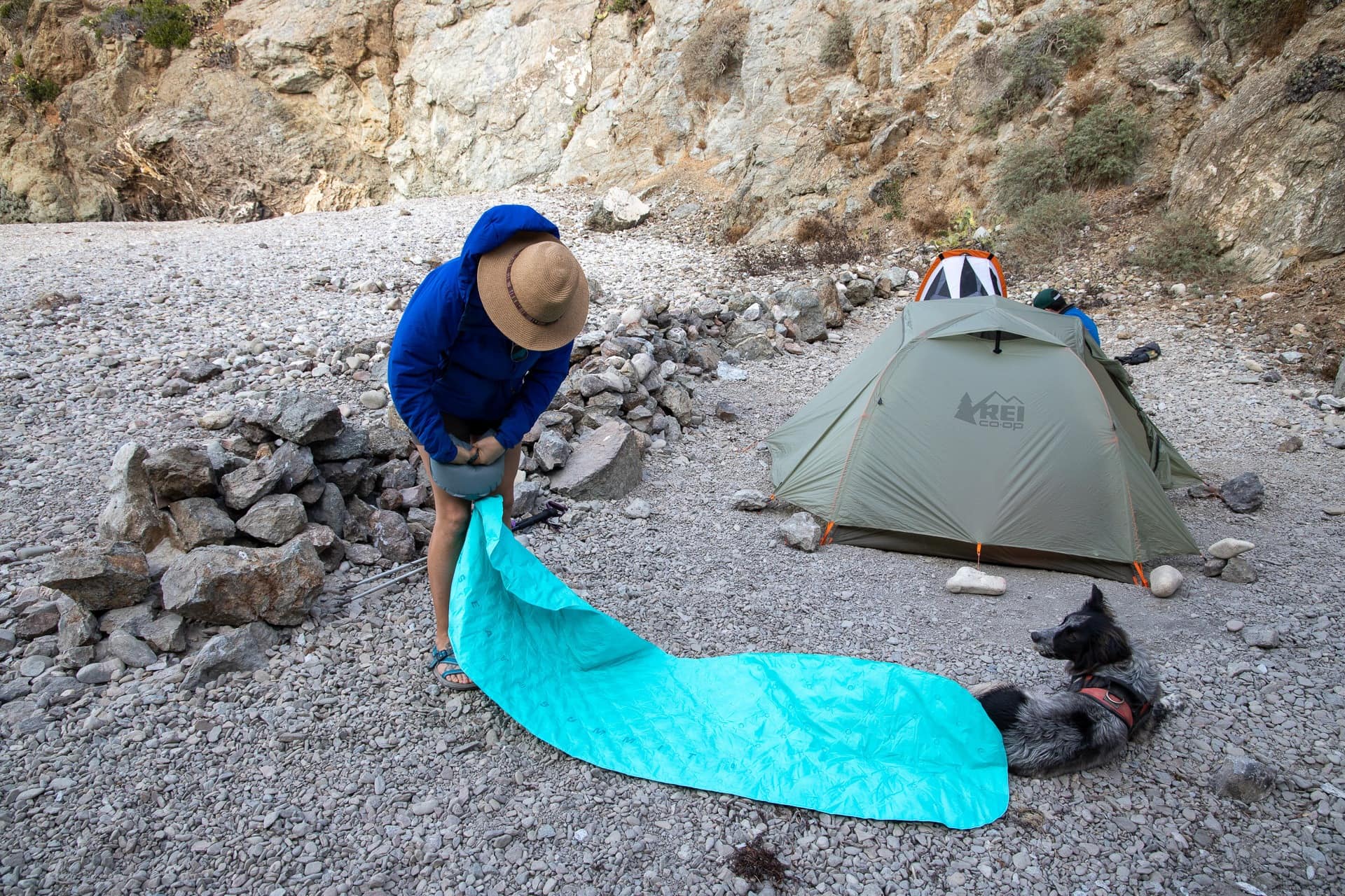 一名妇女在露营地用帆布袋泵炸睡垫