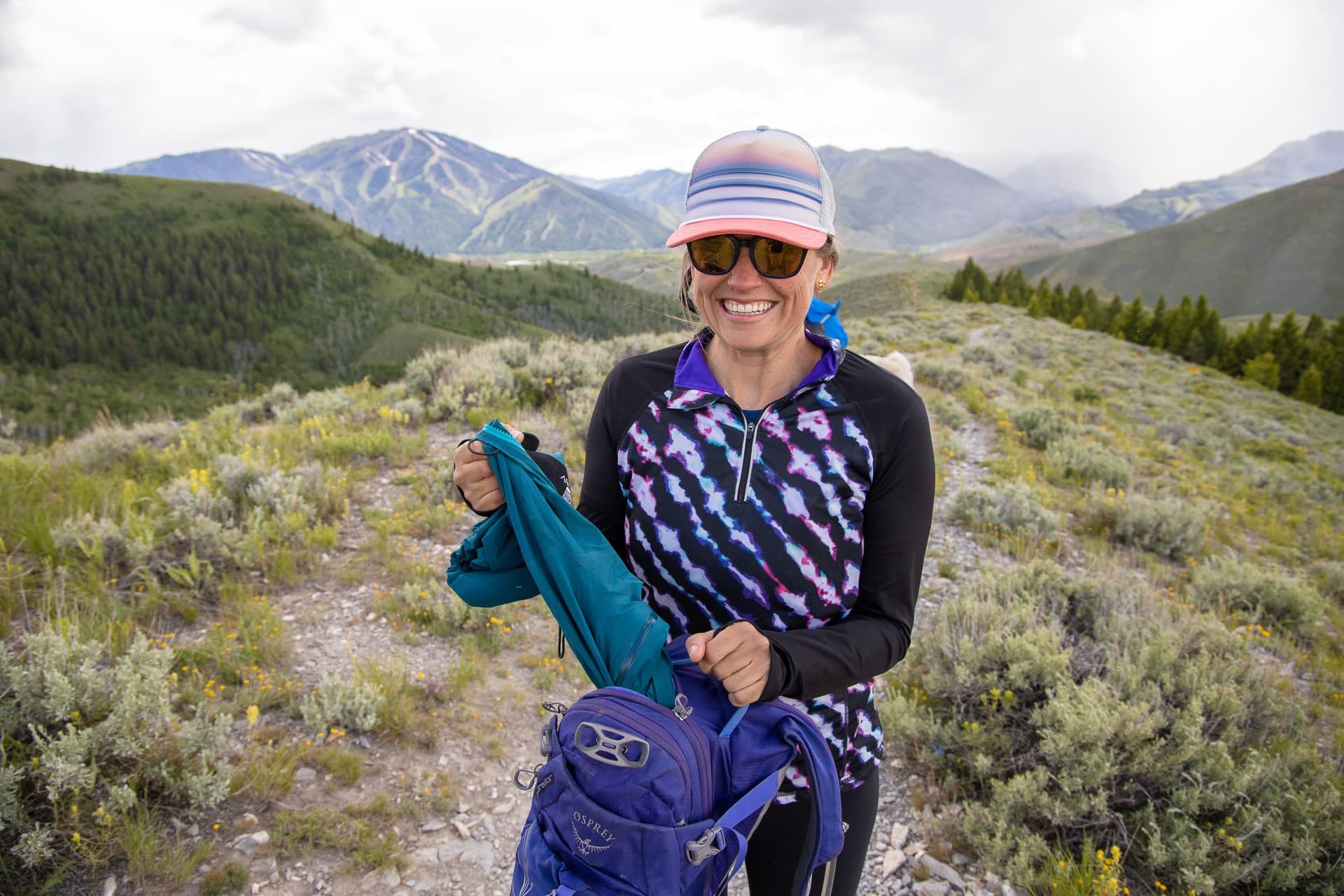 Kristen pulls a rain jacket out of her hiking daypack