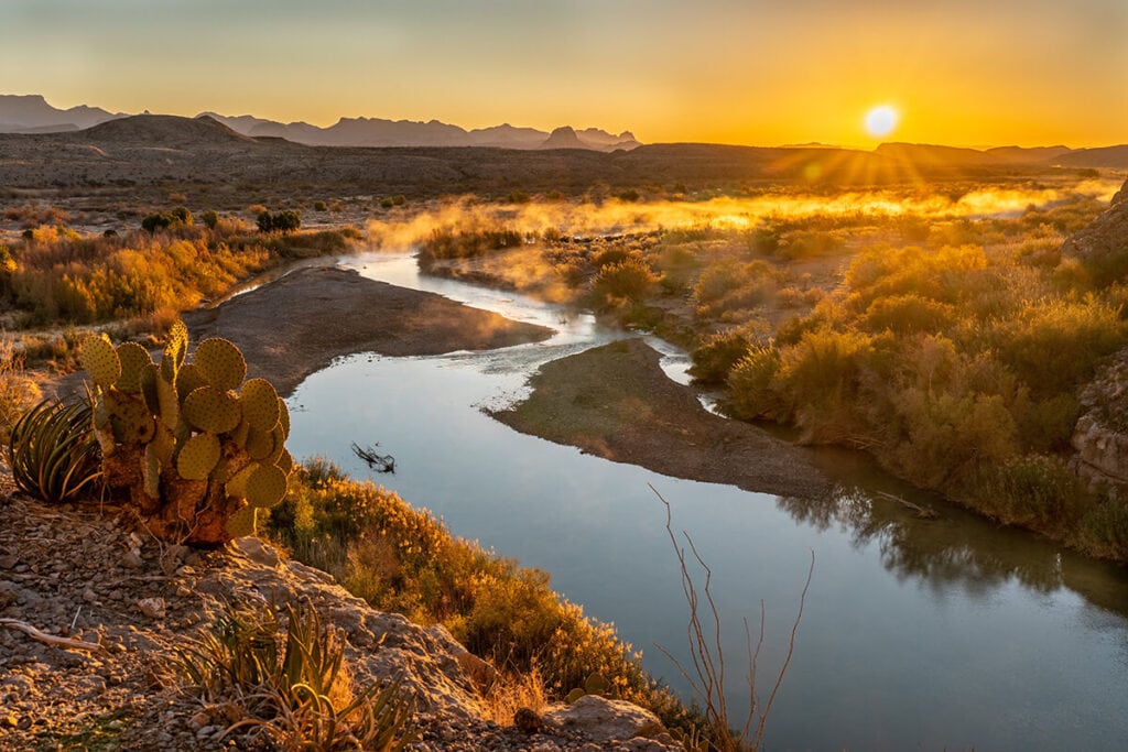 Sun rising over river and landscape in Big Bend National Park in Texas