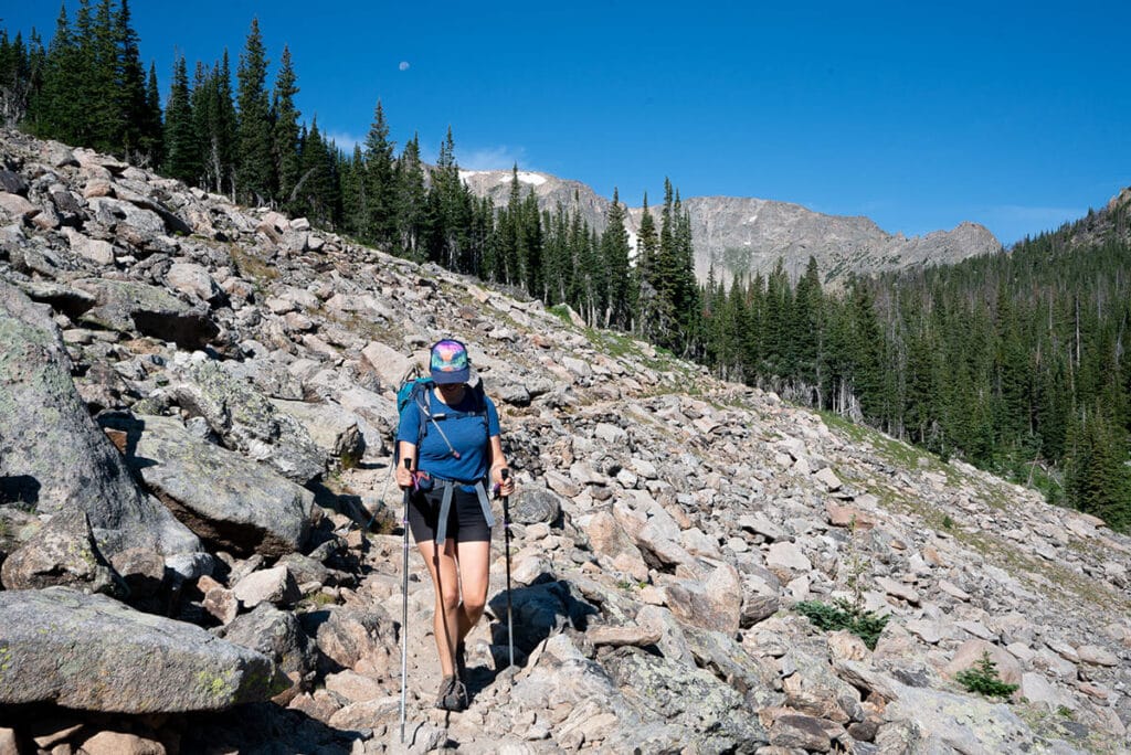 Kristen hiking on rocky terrain using trekking poles