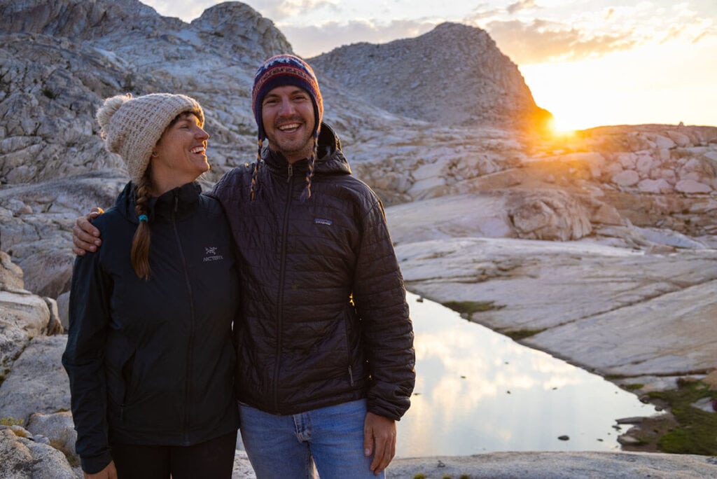 一对穿着Arc'teryx Atom ST和Patagonia Nano Puff合成羽绒服的男女微笑着在日落时分的红杉国家公园进行背包旅行