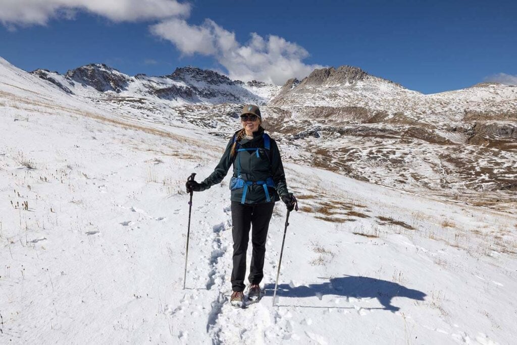克里斯汀在科罗拉多州的雪上徒步旅行，带着登山杆，穿着冬季徒步旅行的衣服