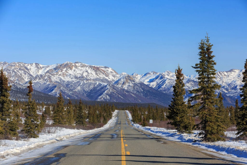 阿拉斯加冬天结冰的道路，远处是白雪皑皑的山脉