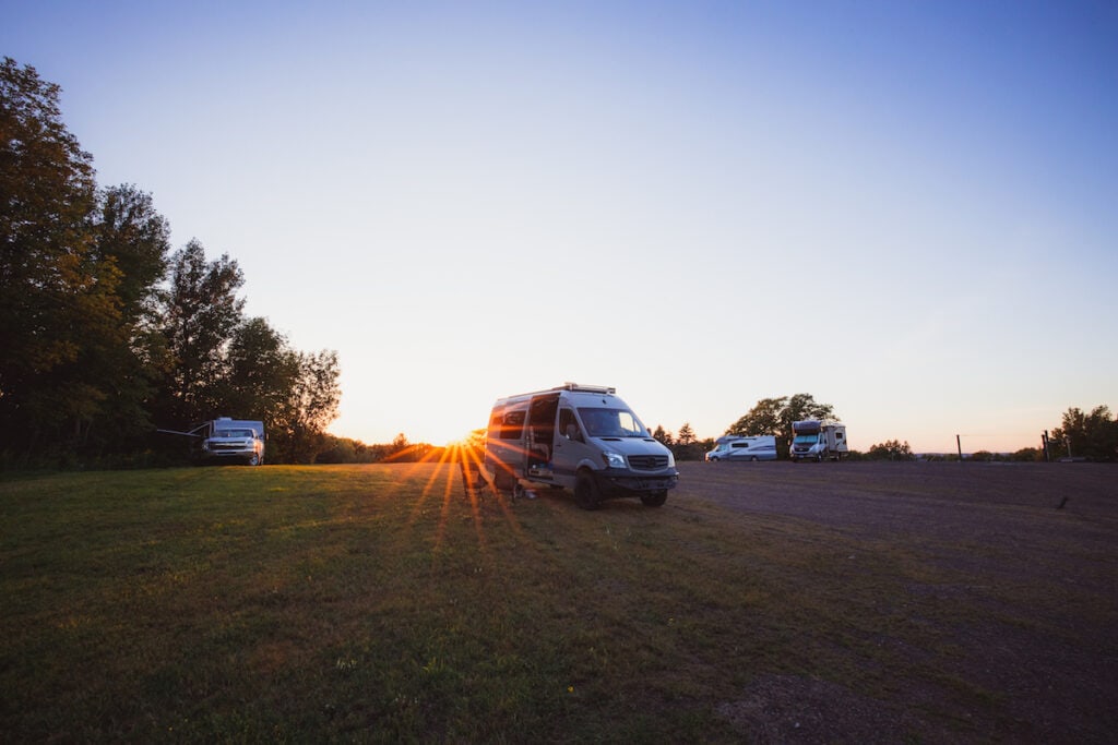 夕阳西下时，几辆露营车分散地停在田野里。他们在密歇根州的Harvest Hosts酒店扎营。