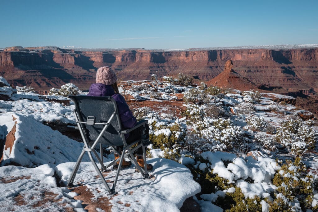 在摩押，一名女子坐在YETI Trailhead营地椅上，面向红色岩石峡谷