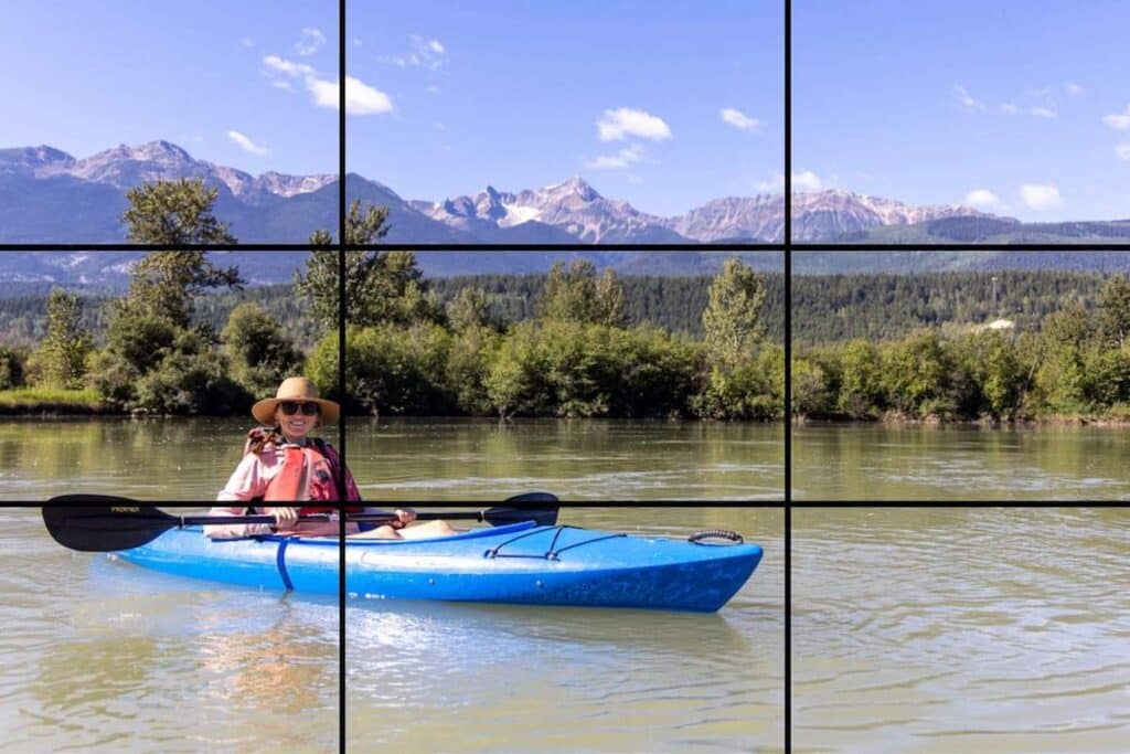 Image of a woman kayaking on a lake. Photo is overlaid with rule of thirds grid lines
